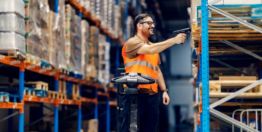 Працівник на складі маркує товар На складі з товаром