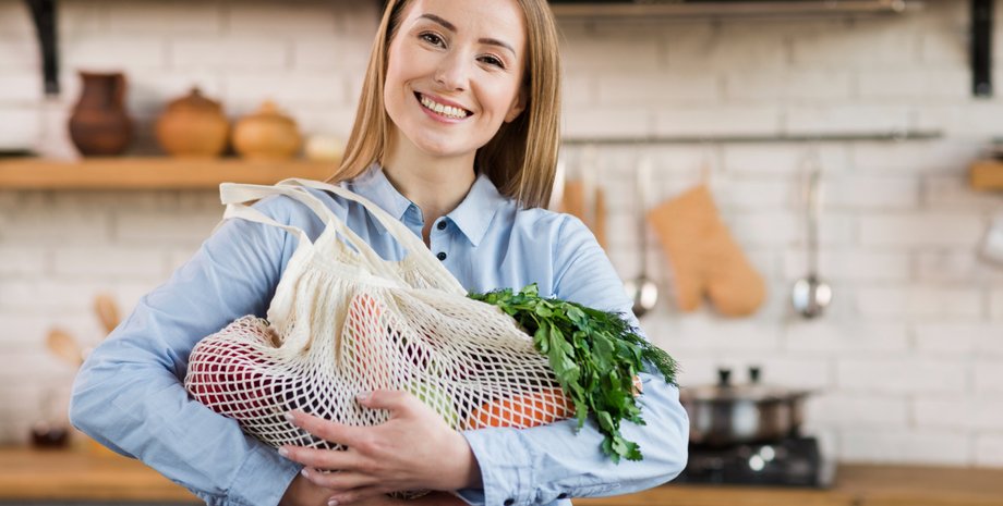 Девушка держит в руках авоську с продуктами