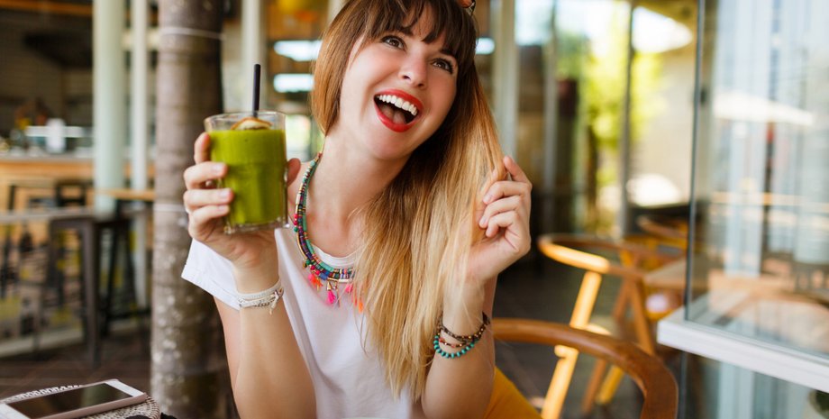 Дівчина тримає склянку зі смузі