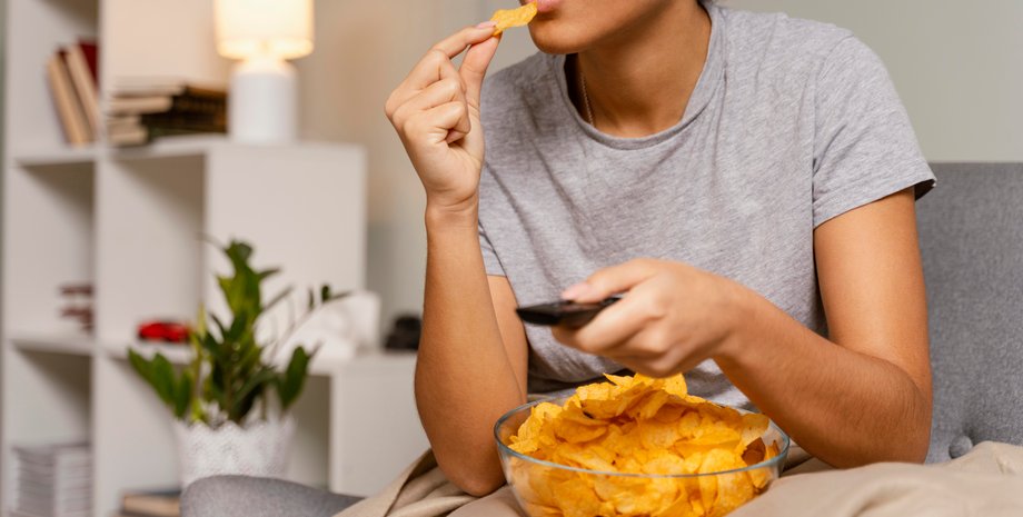 Девушка ест чипсы