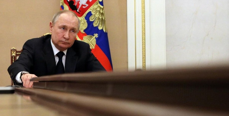 Владимир Путин сидит за столом Владимир Путин сидит за столом