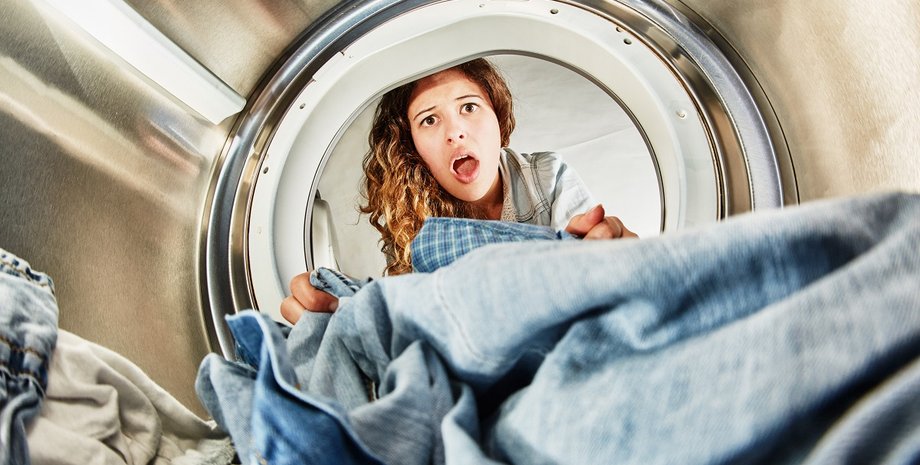 Женщина заглядывает в барабан стиральной машины и с удивлением находит странный предмет среди белья