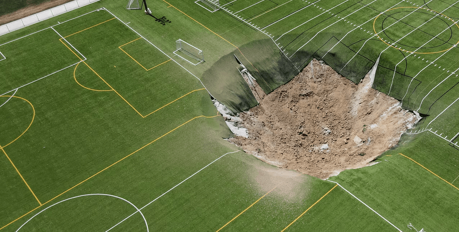 Воронка посеред футбольного поля в США, гігантська воронка, яма, діра, обвал, обвал шахти, грають діти, футбольна команда