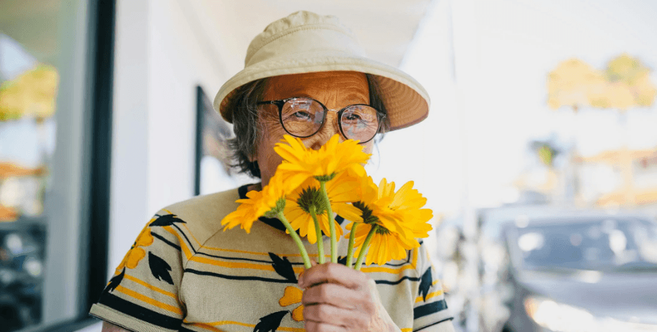 Бабушка нюхает цветы