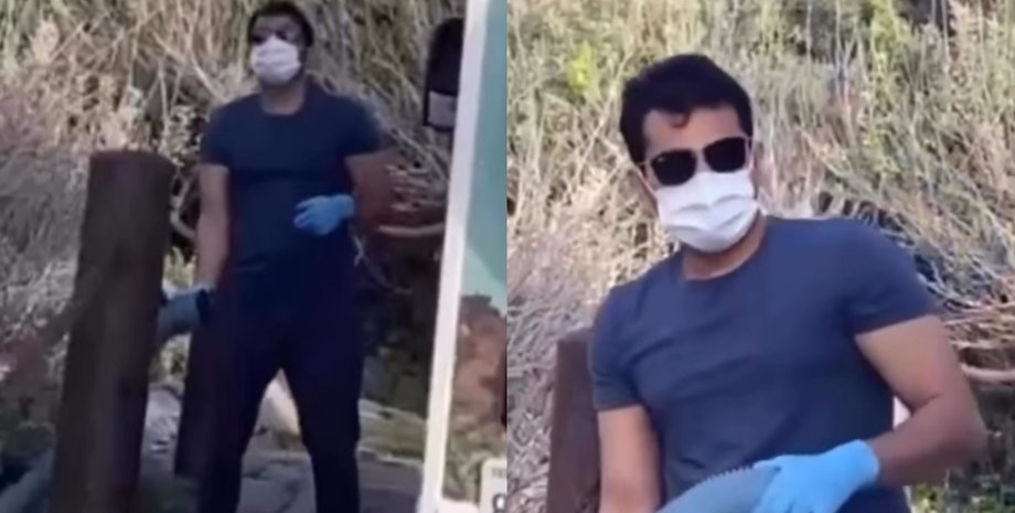 Мужчина в маске и перчатках держит шланг от автофургона возле берега реки в национальном парке Калифорнии