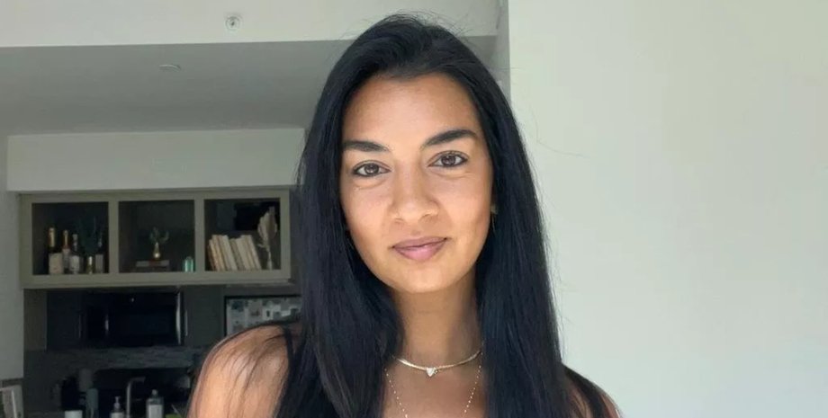 Модель із довгим темним волоссям і природним макіяжем усміхається