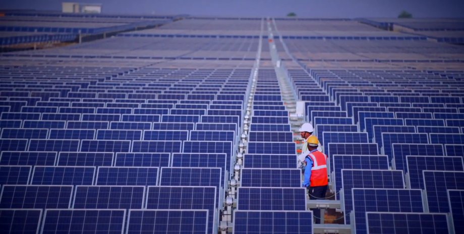 Співробітники оглядають сонячні панелі на електростанції в Індії