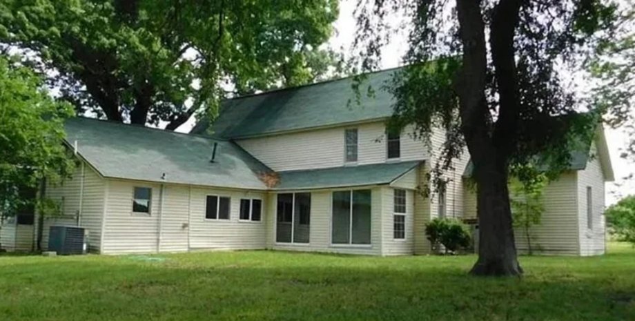 Дерев'яний будинок із зеленим дахом, оточений деревами, який пізніше знищив торнадо