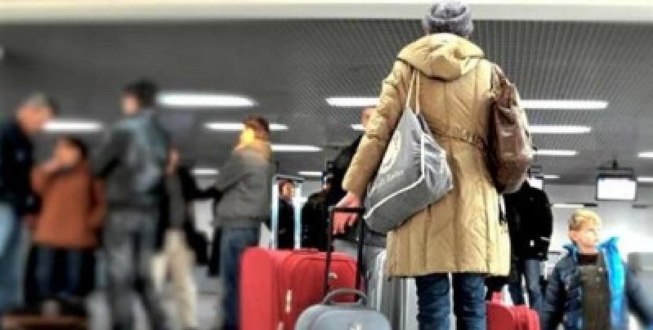 Человек с чемоданами стоит в аэропорту