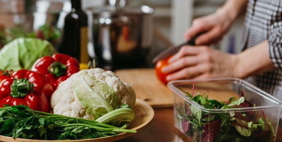 Девушка на кухне нарезает салат