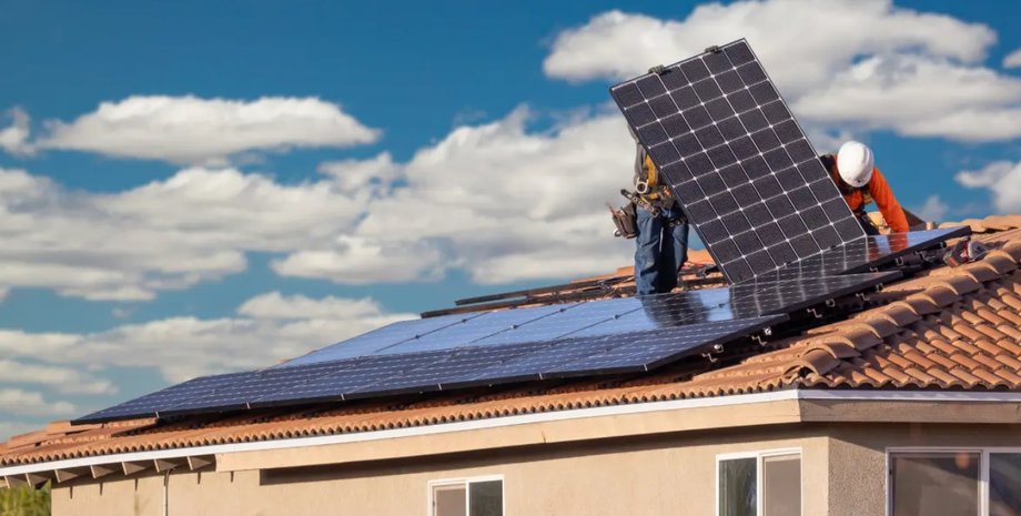 Встановлення сонячних панелей Майстер встановлює сонячні панелі на даху будинку