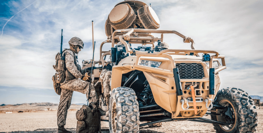 солдат стоїть поряд з технікою