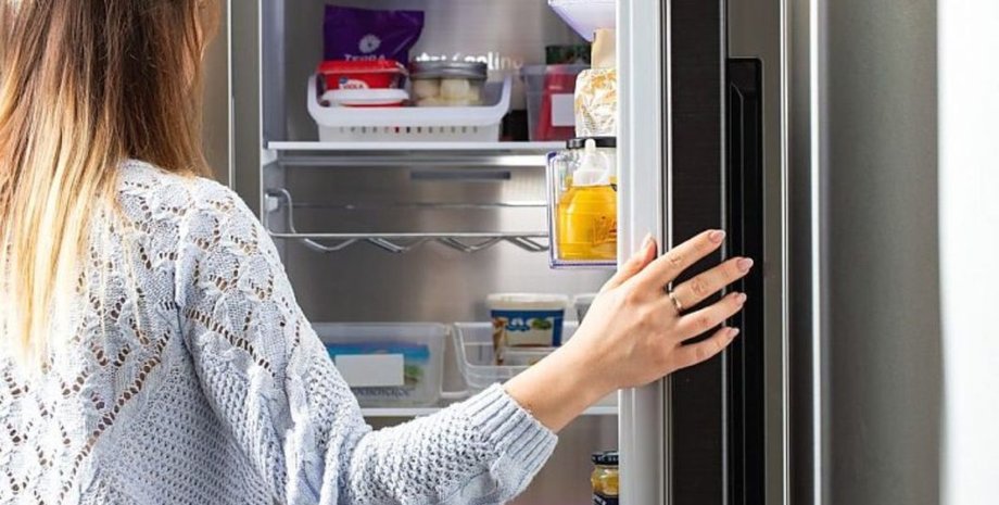 Жінка відкриває холодильник