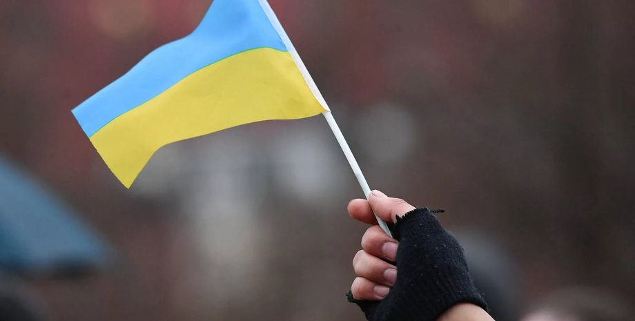 Человек держит флаг в руке