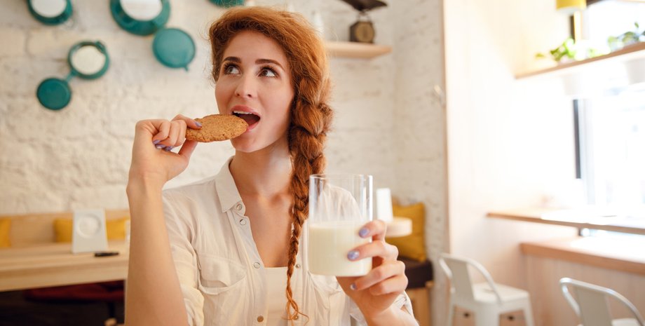 Девушка ест круасан с молоком