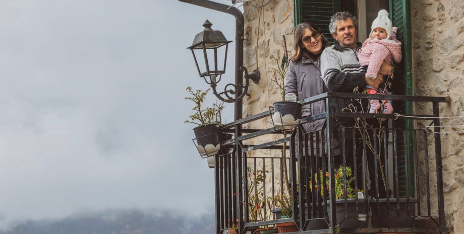 В італійському селі вперше за 30 років народилася дитина Батьки з немовлям на руках, біля свого будинку в селі, де кішок більше ніж людей