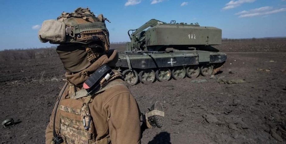 Украинский воин на фоне российской техники.