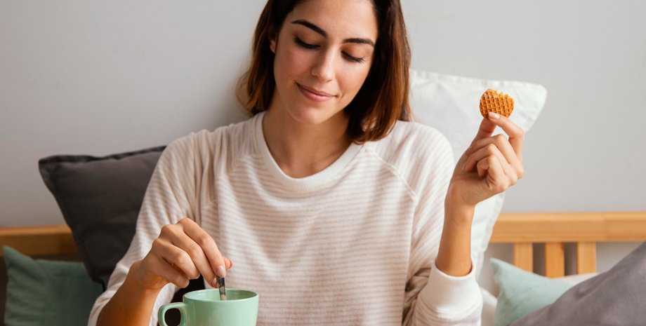 Девушка пьет кофе с печеньем