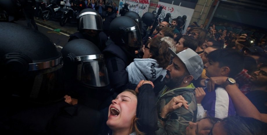 Полицейские бьют каталонцев / Фото: fortune.com
