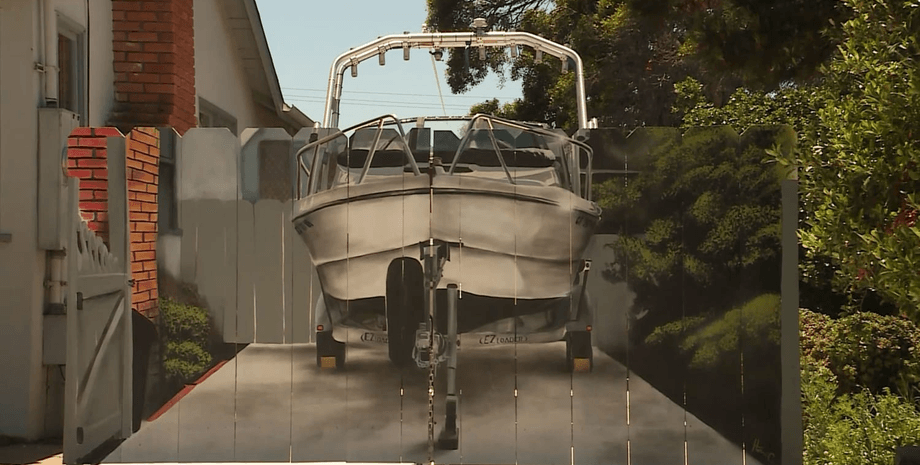 Мужчина нарисовал лодку на заборе, реалистичный рисунок, лодку нарисовали на заборе, оградил лодку, катер, судно, лодка во дворе