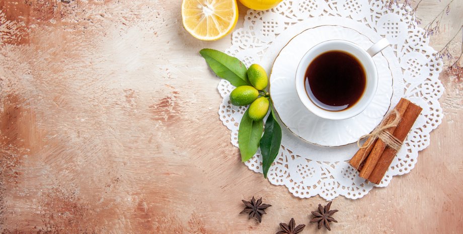 Чашка кофе на столе, лимоны, специи
