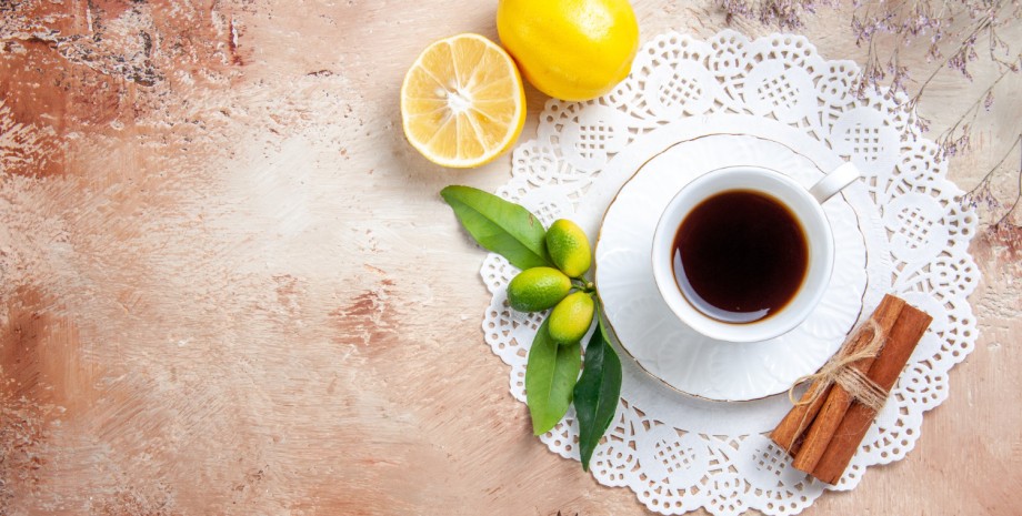 Чашка кофе на столе, лимоны, специи
