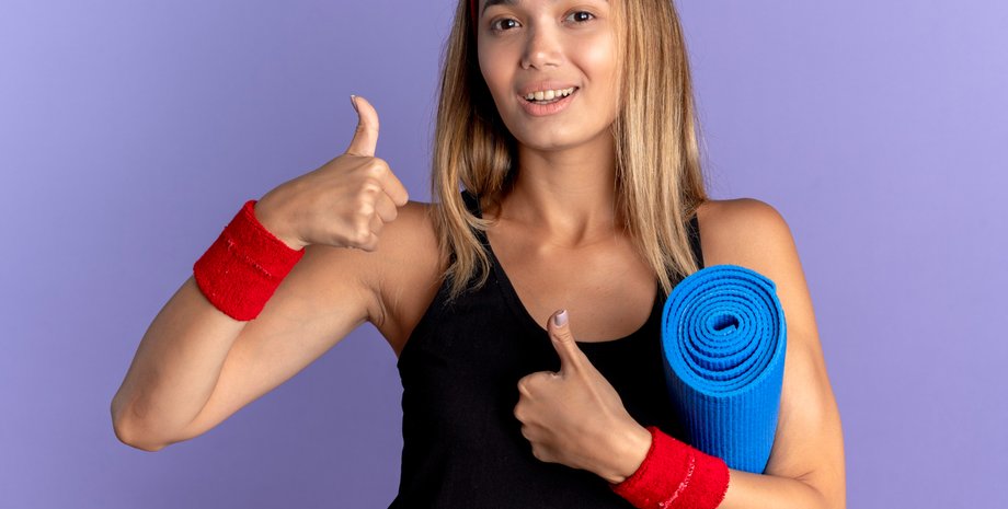 Девушка с ковриком для тренировок