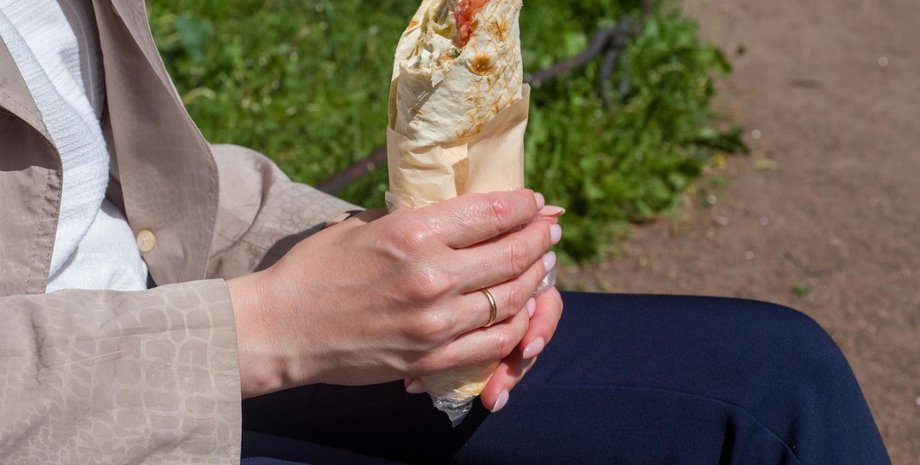 Чоловік тримає шаурму