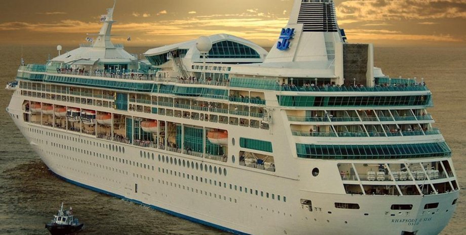 Огромный круизный лайнер Rhapsody of the Seas компании Royal Caribbean в море на фоне заката