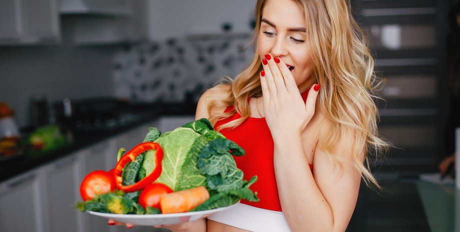 Девушка  держит тарелку с овощами