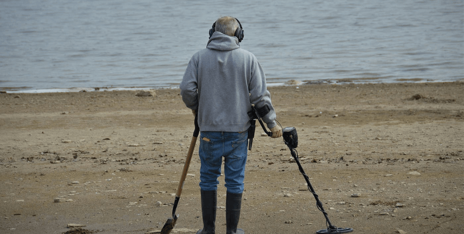 Мужчина с металлоискателем, поиск пропавших предметов, охотник за сокровищами, пляж, необычная находка