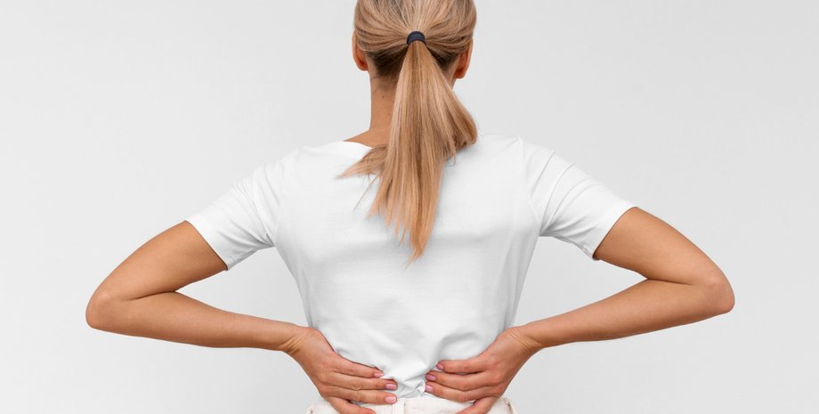 Девушка держится руками за спину