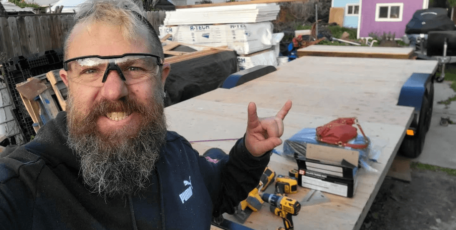 Мужчина строит крошечные домики для бездомных, небольшой дом, дом для бездомного, помогает бездомным, небольшое жилье