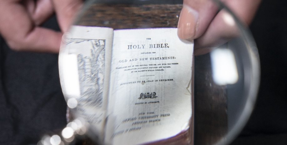 миниатюрная Библия, лупа, пальцы, фото