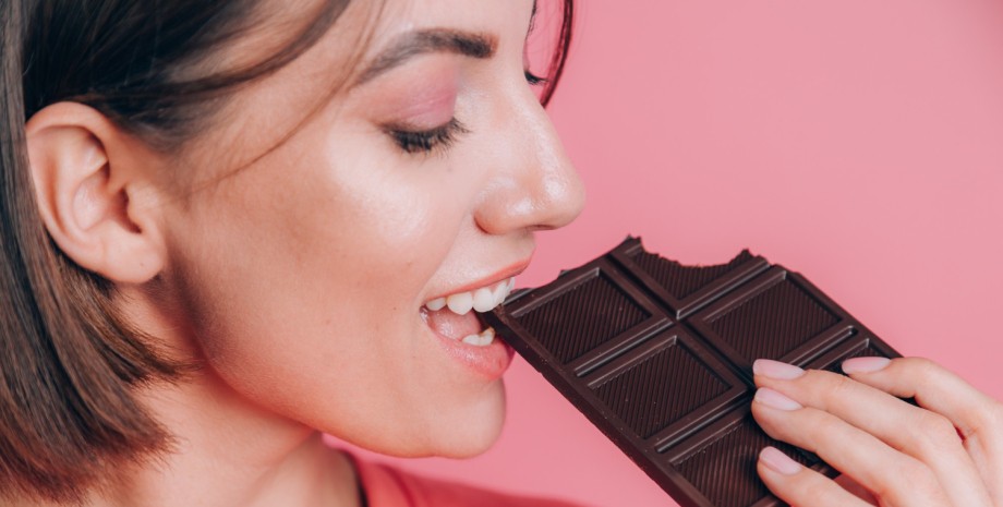 Девушка кусает шоколад