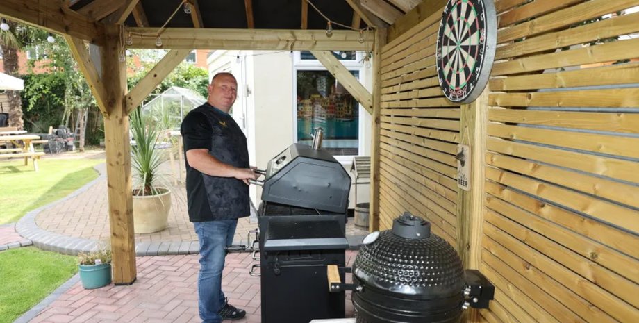 Глен Ганді готує на грилі в садовій зоні бару Cognitos