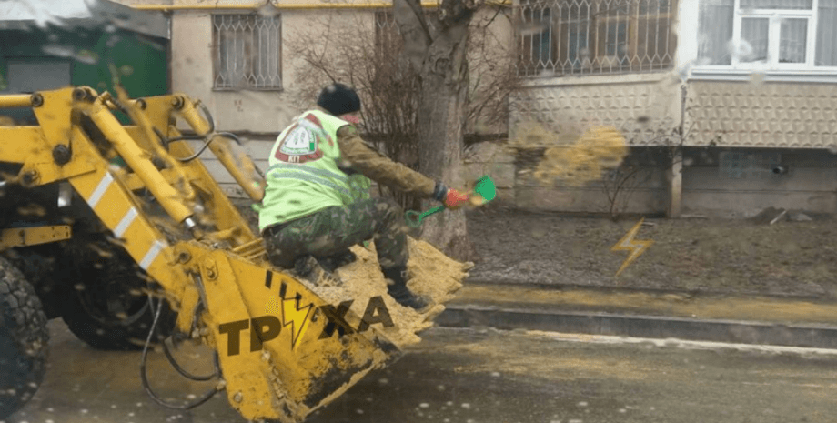 Харьковский "коммунальщик" посыпает дорогу песком из детской лопатки, гололед, Харьков, гололед в Харькове