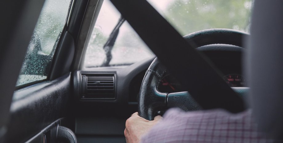 Водитель едет за рулем машины в дождь