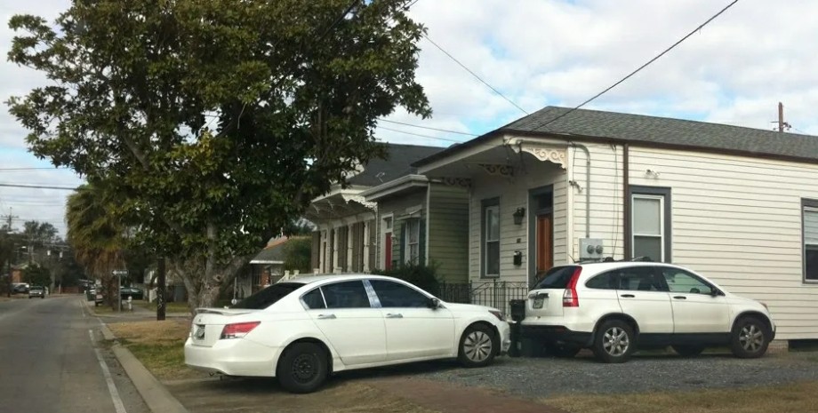 Два прикорковані перед будинком автомобілі автомобілі, парковка, газон