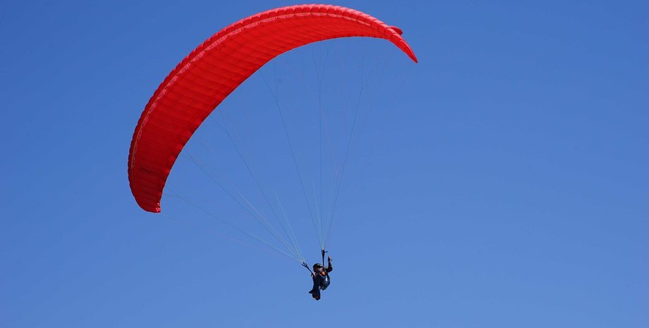 Человек летит с парапланом в небе