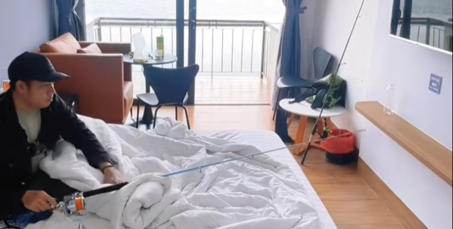 Рибалка закинув вудку з квартири і ловить рибу, лежачи на ліжку