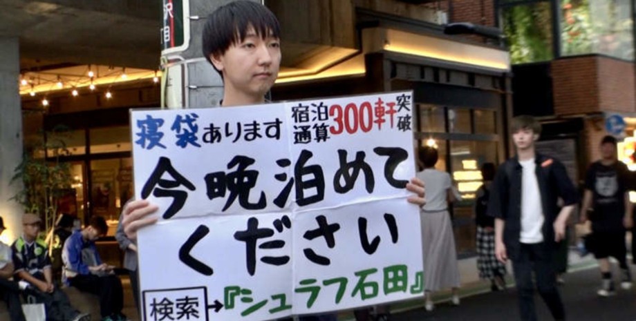Чоловік із плакатом, чоловік не ночує вдома Чоловік з плакатом, чоловік не ночує вдома, чоловік ночує у незнайомців, подорож країною, подорож Японією