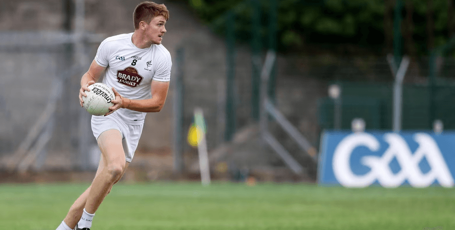 Гравець у білій формі тримає м'яч руками під час тренування