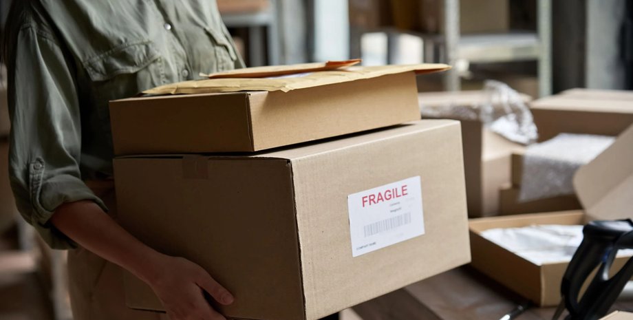 Человек держит в руках несколько картонных коробок, доставка из онлайн-магазина