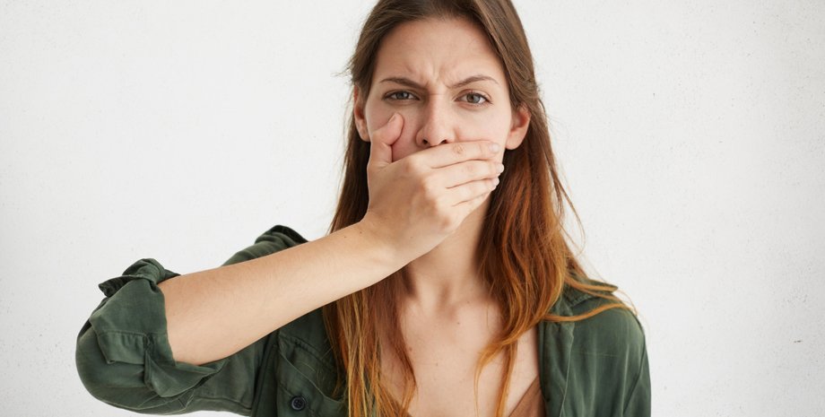 Девушка закрывает рот рукой