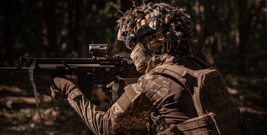 Боец ВСУ Боец ВСУ готовится стрелять на войне в Украине