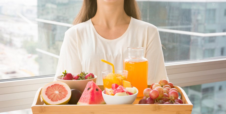 Девушка держит поднос с фруктами