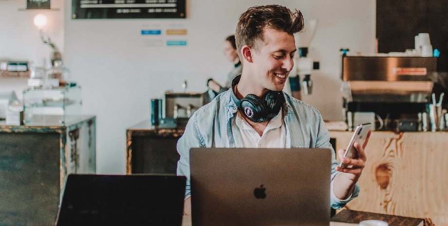 хлопець з ноутбуком і телефоном