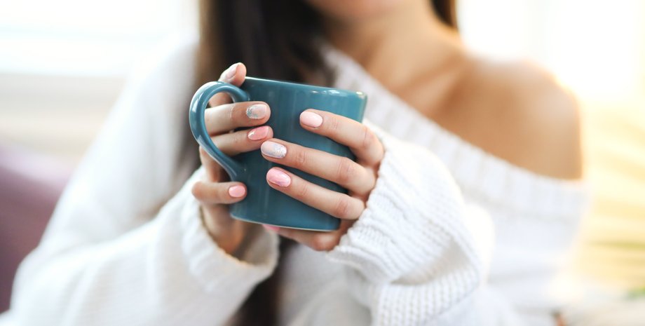 Девушка держит чашку кофе