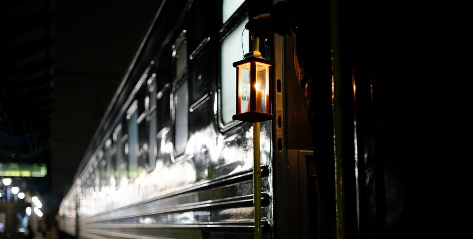 Проводник держит фонарь Проводник поезда Укрзализныци с фонарем